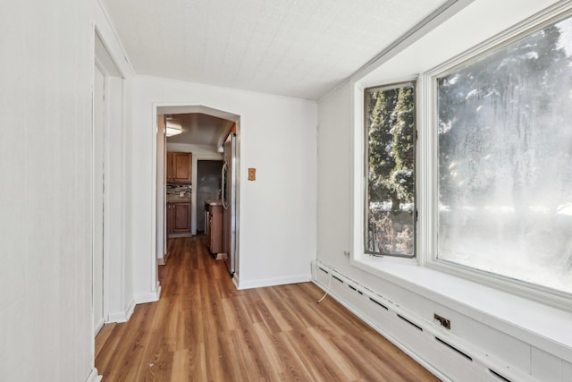 hallway featuring a baseboard heating unit and light wood-type flooring