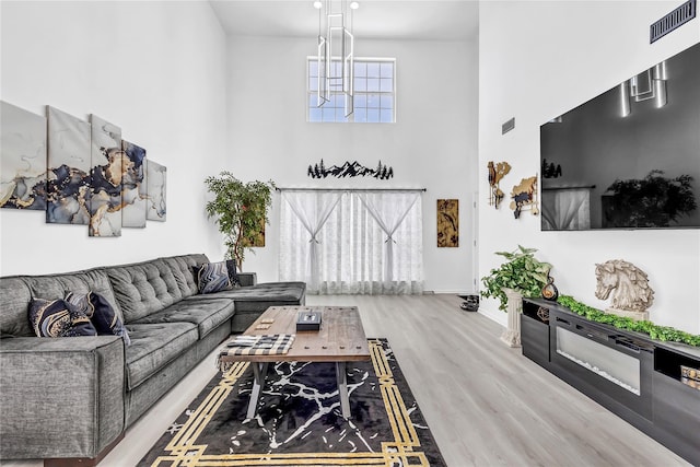 living room featuring hardwood / wood-style flooring and a towering ceiling