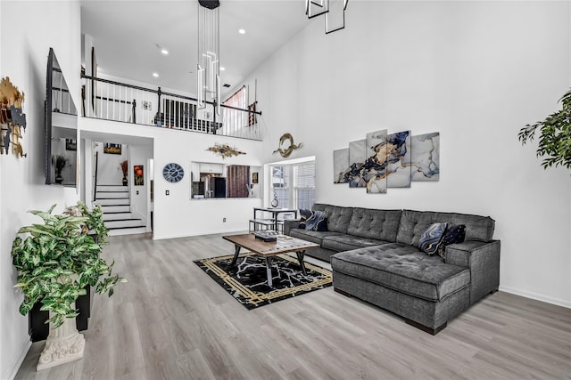 living room with a towering ceiling and hardwood / wood-style floors