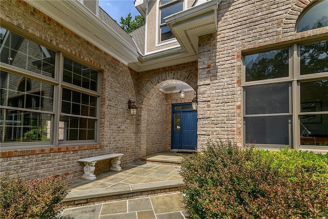 view of exterior entry with a patio area