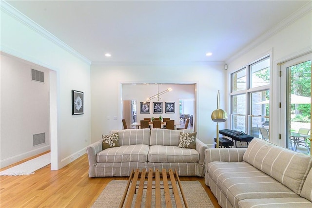 living room featuring ornamental molding and light hardwood / wood-style flooring