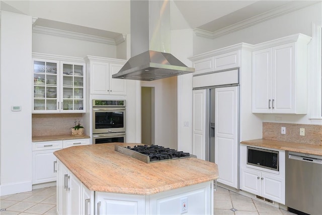 kitchen with white cabinetry, island range hood, built in appliances, light tile patterned floors, and a kitchen island