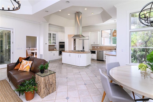 kitchen featuring white cabinetry, a notable chandelier, a raised ceiling, and a kitchen island