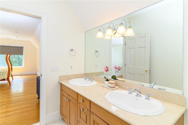 bathroom featuring vanity, vaulted ceiling, and wood-type flooring