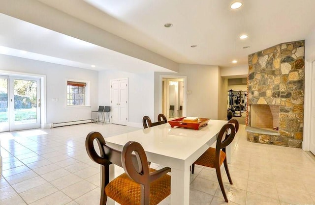 tiled dining area with a fireplace and a baseboard heating unit