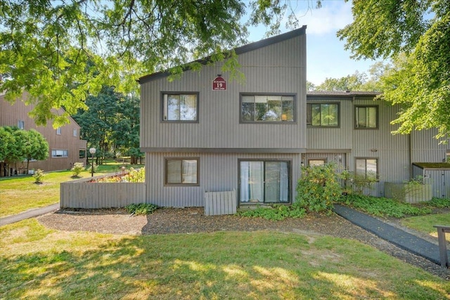 rear view of house featuring a yard