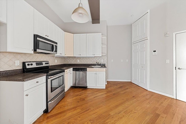 kitchen featuring light hardwood / wood-style flooring, stainless steel appliances, white cabinets, decorative light fixtures, and sink