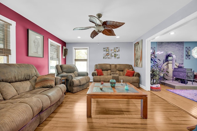 living room with light wood-style floors, ceiling fan, an accent wall, and recessed lighting