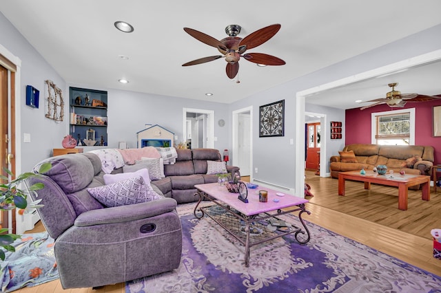 living room featuring recessed lighting, a baseboard radiator, light wood-style flooring, ceiling fan, and baseboards