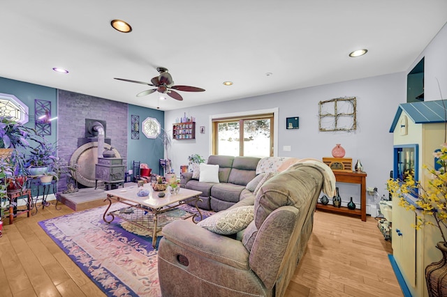 living room featuring a wood stove, light wood-style flooring, and recessed lighting