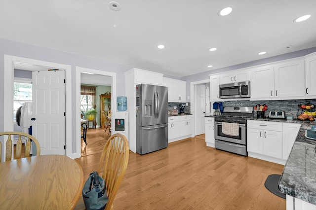 kitchen with light wood finished floors, appliances with stainless steel finishes, and white cabinetry