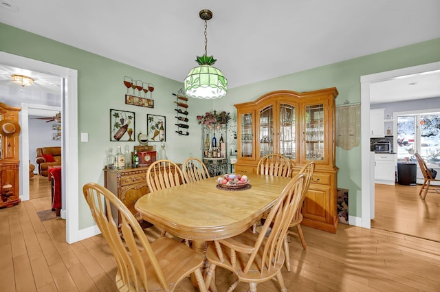 dining area featuring light wood-type flooring and baseboards