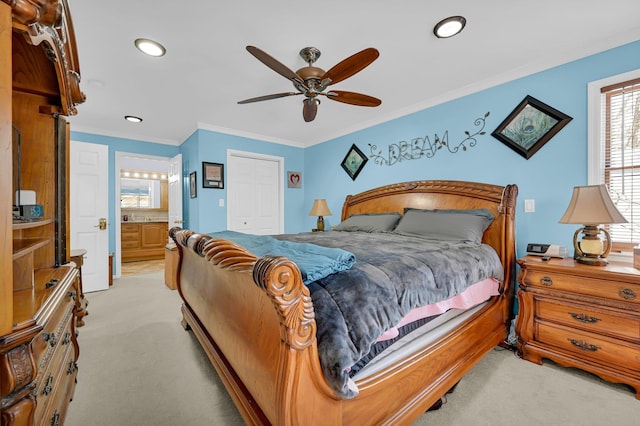 bedroom featuring light carpet, ceiling fan, ornamental molding, and connected bathroom