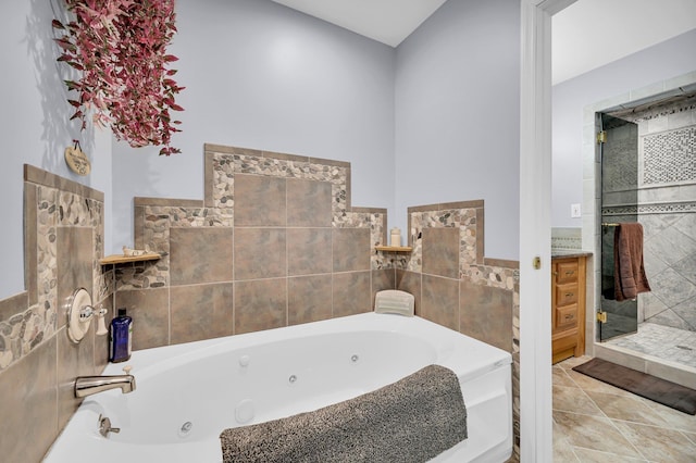 bathroom with a jetted tub, a shower stall, and tile patterned floors