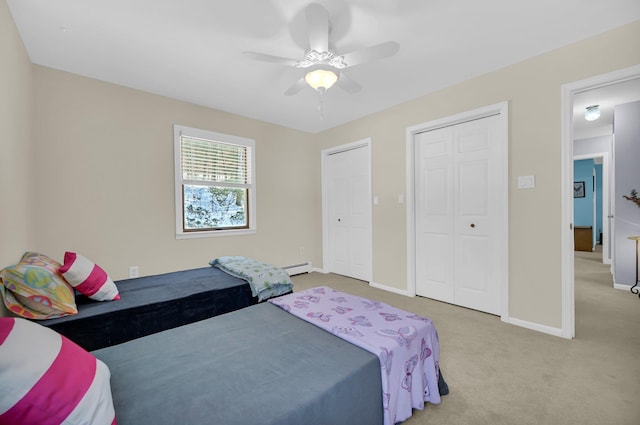 carpeted bedroom with ceiling fan, baseboard heating, and baseboards