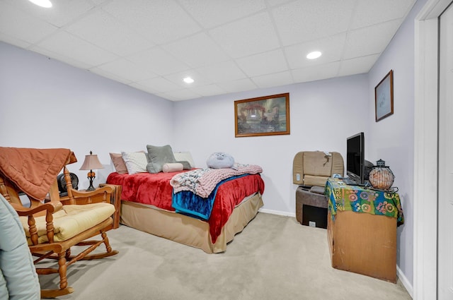 carpeted bedroom featuring a drop ceiling, recessed lighting, and baseboards