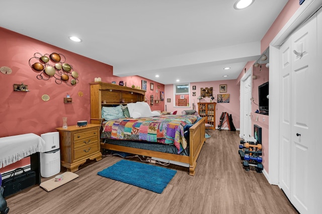 bedroom with a fireplace, recessed lighting, a closet, wood finished floors, and baseboards