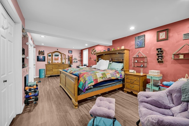 bedroom with recessed lighting, a closet, and wood finished floors