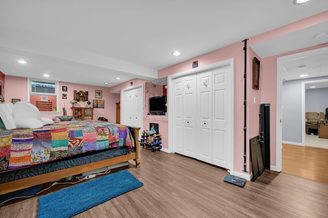 bedroom with multiple closets, recessed lighting, baseboards, and wood finished floors