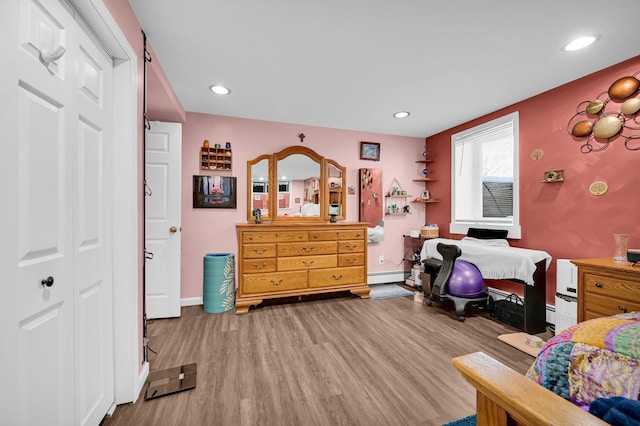 bedroom with a baseboard radiator, light wood-style flooring, baseboards, and recessed lighting