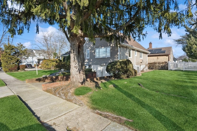 view of home's exterior with a lawn and solar panels