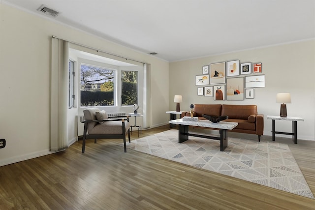 living room featuring hardwood / wood-style flooring and ornamental molding