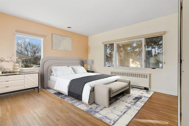 bedroom featuring radiator and hardwood / wood-style flooring