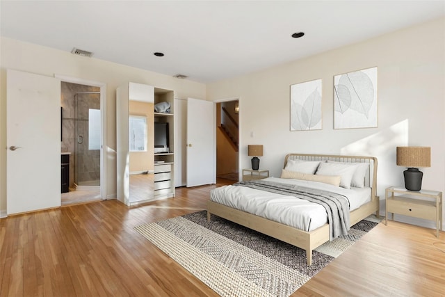 bedroom with wood-type flooring and connected bathroom