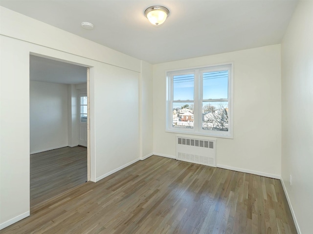 spare room with hardwood / wood-style flooring and radiator