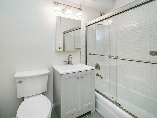 full bathroom featuring enclosed tub / shower combo, vanity, and toilet