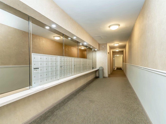 hall with carpet floors and a mail area