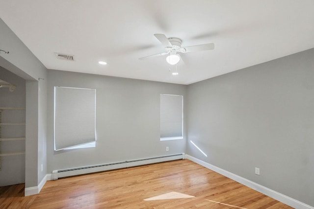 empty room with a baseboard radiator, ceiling fan, and light hardwood / wood-style floors