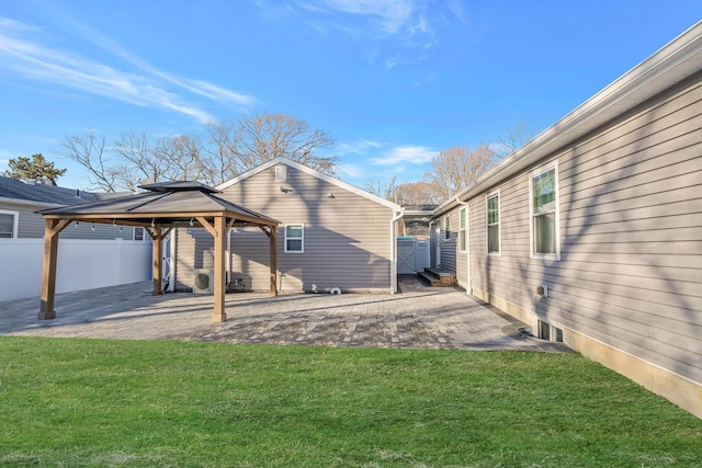 rear view of property featuring a gazebo, a lawn, and a patio area