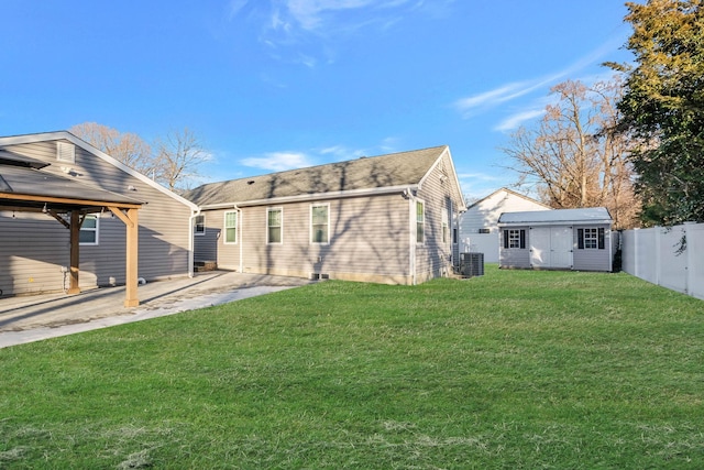 back of house featuring cooling unit, a storage shed, a yard, and a patio area