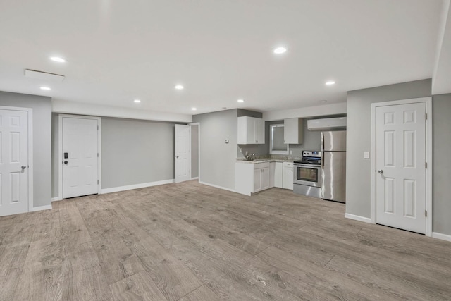 kitchen featuring sink, light hardwood / wood-style floors, extractor fan, and appliances with stainless steel finishes