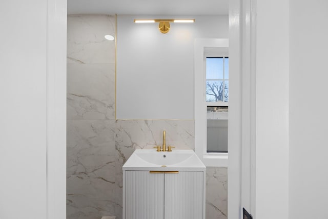 bathroom featuring vanity and tile walls