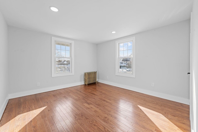 unfurnished room with wood-type flooring and radiator