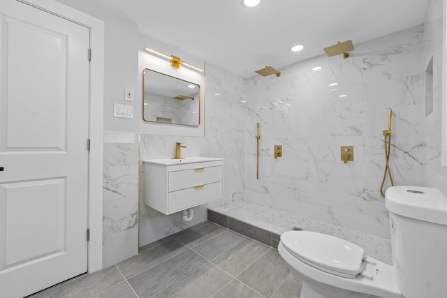 bathroom featuring vanity, toilet, tile walls, and a tile shower