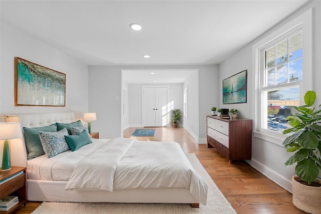 bedroom with multiple windows and light hardwood / wood-style flooring