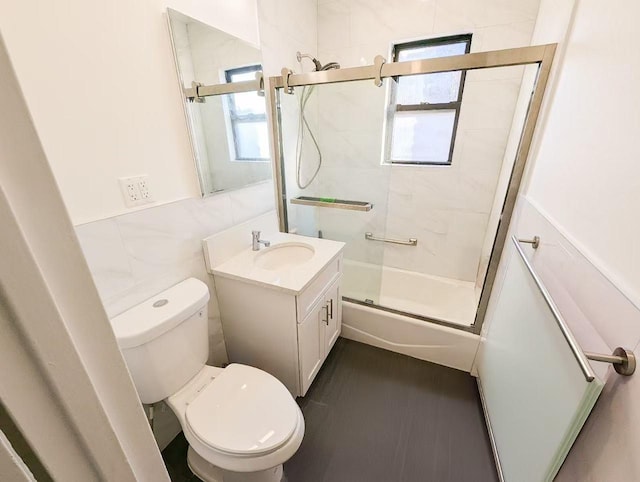 full bathroom featuring enclosed tub / shower combo, a healthy amount of sunlight, tile walls, and toilet