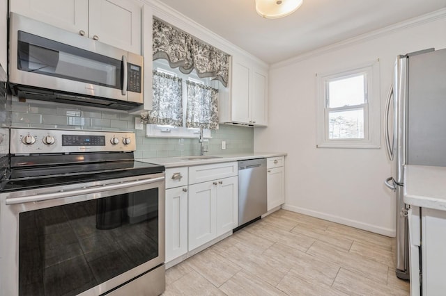 kitchen with a healthy amount of sunlight, appliances with stainless steel finishes, sink, and white cabinets