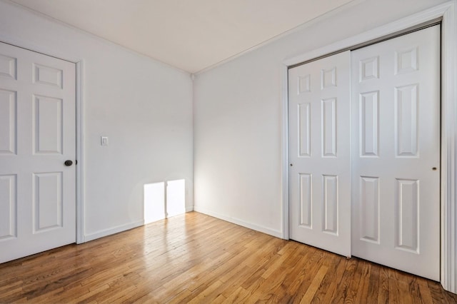 unfurnished bedroom with light hardwood / wood-style flooring and a closet