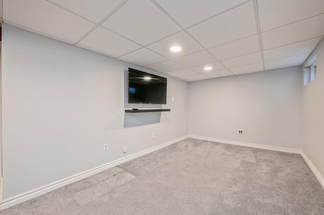 basement with a paneled ceiling and carpet