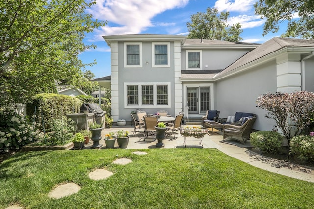 back of house with a yard, a patio area, outdoor lounge area, and stucco siding