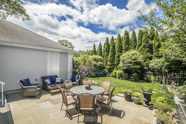 view of patio / terrace with outdoor dining area, fence, and an outdoor hangout area