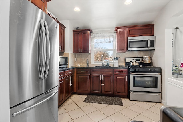 kitchen featuring stainless steel appliances, light tile patterned flooring, sink, and backsplash