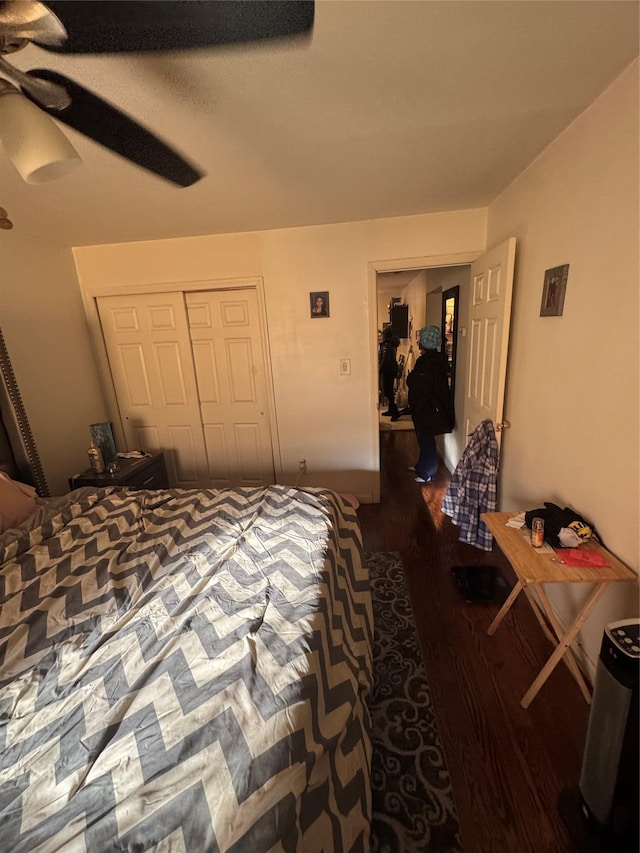 bedroom with dark hardwood / wood-style floors, ceiling fan, and a closet