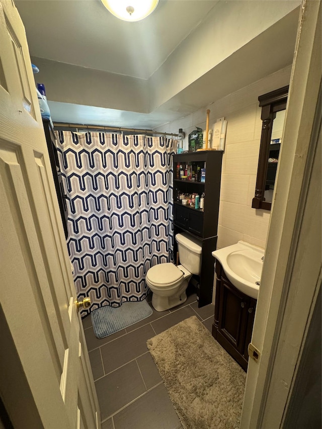 bathroom with a shower with curtain, tile patterned floors, vanity, and toilet