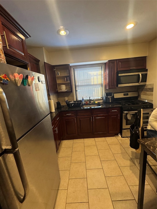 kitchen with sink, stainless steel appliances, and light tile patterned flooring