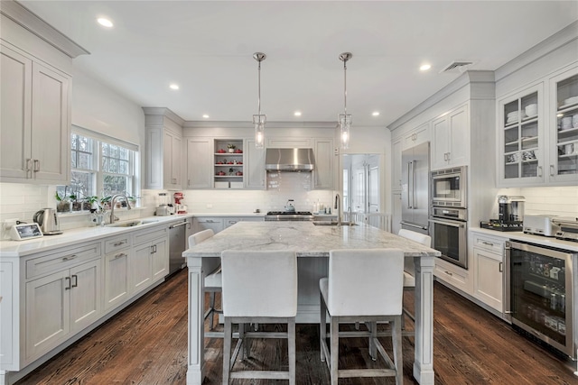 kitchen with stainless steel appliances, a kitchen island with sink, white cabinets, and wine cooler